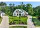 Stunning exterior of a luxury home with a circular driveway, lush lawn, and mature trees at 1409 Montvale Ridge Dr, Cary, NC 27519