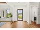 Bright foyer featuring hardwood herringbone floors, a black-framed glass front door, and a view of the manicured front yard at 1409 Montvale Ridge Dr, Cary, NC 27519