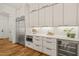 Bright kitchen with stainless steel fridge, wine fridge, white cabinets, and quartz countertops at 1409 Montvale Ridge Dr, Cary, NC 27519