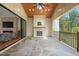 Covered patio features stone floors, fireplace, wood paneled ceiling, and views to the backyard and living room at 1409 Montvale Ridge Dr, Cary, NC 27519