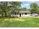 Wide angle view of the backyard and white house, with a wooded backdrop at 141 Weston Rd, Garner, NC 27529