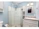 Bathroom featuring a glass enclosed shower, white vanity and blue walls at 141 Weston Rd, Garner, NC 27529
