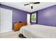 This bedroom features purple walls, a ceiling fan, and a view of the outdoors through the window at 141 Weston Rd, Garner, NC 27529