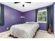 Cozy bedroom with purple walls, ceiling fan, window and guitar in the corner at 141 Weston Rd, Garner, NC 27529