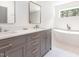 Elegant bathroom with double sink vanity, quartz countertop, decorative mirrors, and modern soaking tub at 1605 Bobwhite Ln, Rocky Mount, NC 27804