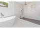 Luxurious bathroom with marble tiling, rain shower, hand shower, and modern soaking tub near window at 1605 Bobwhite Ln, Rocky Mount, NC 27804