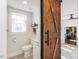 Stylish bathroom with a modern sliding barn door and elegant fixtures at 1625 Haystack Ln, Burlington, NC 27217