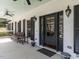 Inviting front porch featuring dark shutters, a black door and space for seating and potted plants at 1625 Haystack Ln, Burlington, NC 27217