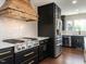Modern kitchen boasts stainless steel appliances, dark cabinets, and a custom wood range hood at 1625 Haystack Ln, Burlington, NC 27217