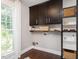 Bright laundry room with shaker cabinets, open shelving, and a large window for natural light at 1625 Haystack Ln, Burlington, NC 27217