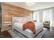 Comfortable main bedroom featuring wood accent wall, plush bedding, and natural light at 1625 Haystack Ln, Burlington, NC 27217