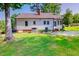 Expansive backyard featuring a well-maintained lawn, mature trees, and the back of the house at 171 Magnolia Dr, Roxboro, NC 27573