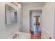 Bright bathroom with white vanity, neutral walls, and view into another room with wood accents at 171 Magnolia Dr, Roxboro, NC 27573