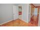 Spacious bedroom featuring hardwood floors, neutral walls, and an open doorway leading to the kitchen area at 171 Magnolia Dr, Roxboro, NC 27573