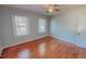 Bedroom featuring hardwood floors, a ceiling fan, and natural light coming in from multiple windows at 171 Magnolia Dr, Roxboro, NC 27573