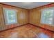 Bedroom with natural wood paneling, trim, and flooring and natural light from two windows at 171 Magnolia Dr, Roxboro, NC 27573