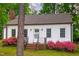 Charming home featuring a brick entryway and surrounded by lush greenery and flowering plants at 171 Magnolia Dr, Roxboro, NC 27573