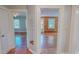 Hallway with wood floors offering access to multiple rooms with natural light and beautiful wooden accents at 171 Magnolia Dr, Roxboro, NC 27573