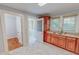 Functional kitchen area featuring wood cabinets, ample countertop space, and marble-patterned floors at 171 Magnolia Dr, Roxboro, NC 27573