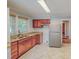 Well-lit kitchen with stainless steel appliances, wood cabinets, and marble-patterned floors at 171 Magnolia Dr, Roxboro, NC 27573