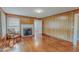 Inviting living room with wood-paneled walls, a brick fireplace, and gleaming hardwood floors at 171 Magnolia Dr, Roxboro, NC 27573
