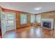 Comfortable living space showcasing wood-paneled walls, a brick fireplace, and natural light at 171 Magnolia Dr, Roxboro, NC 27573