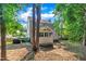 Back of the home with a screened-in porch, mature trees and landscaping, and a wooden fence at 1905 Indianwood Ct, Raleigh, NC 27604