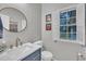Tastefully decorated powder room with a modern vanity, round mirror, and patterned wallpaper at 1905 Indianwood Ct, Raleigh, NC 27604