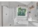 Bright bathroom showcasing a glass shower, garden tub with tiled backsplash, and hanging plants at 1905 Indianwood Ct, Raleigh, NC 27604