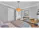 Bright bedroom with hardwood floors, a pendant light fixture, an accent chair, and a mirror at 1905 Indianwood Ct, Raleigh, NC 27604