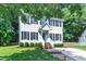 Two-story home featuring black shutters, a well-manicured lawn, and a brick pathway leading to the front entrance at 1905 Indianwood Ct, Raleigh, NC 27604