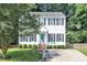 Charming two-story home with a well-manicured lawn and a welcoming front entrance with a teal-colored front door at 1905 Indianwood Ct, Raleigh, NC 27604