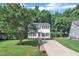 Two-story home featuring a well-kept lawn, mature trees, and a paved driveway leading to the front entrance at 1905 Indianwood Ct, Raleigh, NC 27604