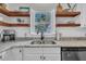 Kitchen with white cabinets and stainless steel double basin sink overlooking backyard at 1905 Indianwood Ct, Raleigh, NC 27604