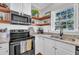 Kitchen with stainless steel appliances, floating shelves and modern finishes at 1905 Indianwood Ct, Raleigh, NC 27604