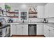 Modern kitchen with white cabinets, granite countertops, stainless steel appliances, and floating wood shelves at 1905 Indianwood Ct, Raleigh, NC 27604