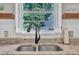 Close up of kitchen sink area, featuring floating shelves and a view of the backyard at 1905 Indianwood Ct, Raleigh, NC 27604