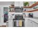 Updated kitchen with stainless steel appliances, floating shelves and modern finishes at 1905 Indianwood Ct, Raleigh, NC 27604