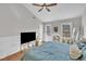 Bright main bedroom with a ceiling fan, hardwood floors, natural light, and a flat screen television at 1905 Indianwood Ct, Raleigh, NC 27604