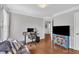 Well-lit office with hardwood floors, ample seating, a large television, and a bright blue media cabinet at 1905 Indianwood Ct, Raleigh, NC 27604