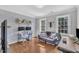A home office boasts large windows, hardwood floors, stylish wallpaper, and ample seating and work spaces at 1905 Indianwood Ct, Raleigh, NC 27604