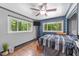 Bedroom features hardwood floors, ceiling fan, and multiple windows at 2005 Cole Mill Rd, Durham, NC 27712
