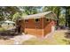 Back exterior of home featuring brick facade, backyard patio, and mature tree at 2005 Cole Mill Rd, Durham, NC 27712