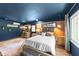Comfortable main bedroom showcasing an exposed brick wall, wooden floors, and ample natural light at 2005 Cole Mill Rd, Durham, NC 27712