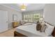Bright bedroom with an accent chair, light wood floors, and a three-panel window at 2057 Tanners Mill Dr, Durham, NC 27703