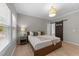 Bright bedroom with light wood floors, decorative light fixture, and sliding barn door to bathroom at 2057 Tanners Mill Dr, Durham, NC 27703
