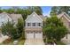 Two-story home featuring a stone facade, a two-car garage, and well-maintained landscaping at 2057 Tanners Mill Dr, Durham, NC 27703