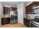 Well-equipped kitchen with stainless steel appliances and dark wood cabinets at 2057 Tanners Mill Dr, Durham, NC 27703