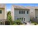 Exterior shot of the rear of the house, featuring gray siding, windows, and a small patio area at 2057 Tanners Mill Dr, Durham, NC 27703