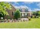 Classic brick home featuring dormer windows and a welcoming front porch with white columns at 206 W Stoneybrook Ct, Benson, NC 27504